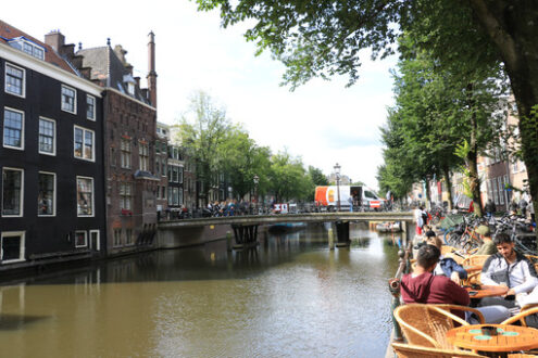 Coffee on a canal. Tables with seated people, In the background - MyVideoimage.com