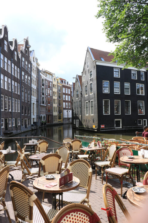 Coffee on a canal. Wooden tables and chairs in the bar. On the t - MyVideoimage.com