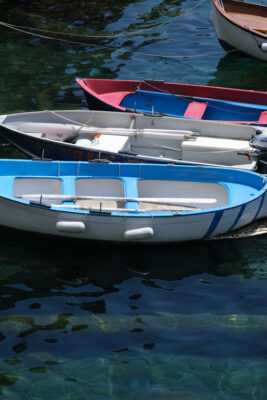 Colored boats on the blue sea. Riomaggiore, Cinque Terre. Stock Photos. - LEphotoart.com