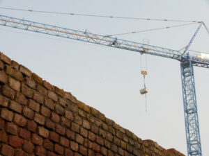 Construction site with cranes and a solid brick wall. - MyVideoimage.com