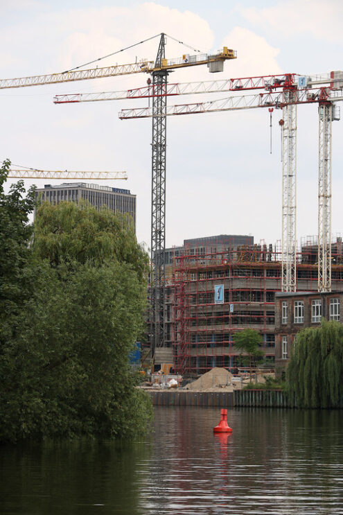 Construction site with cranes. A construction site on the river bank in Berlin. Tower cranes rise into the sky.  Cantieri edili. - MyVideoimage.com | Foto stock & Video footage