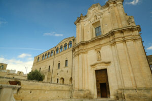 Convent in Matera. Church and Convent of Sant’Agostino in Matera. Courtyard with olive trees with leaves moving in the wind. - MyVideoimage.com | Foto stock & Video footage