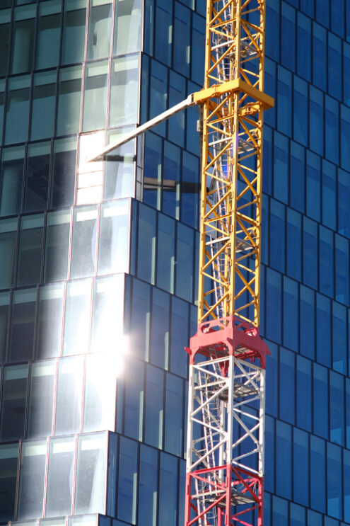 Costruzione grattacielo PwC a Milano. Construction site tower crane for the construction of the PWC Libeskind skyscraper in Milan. Glass facade with sun reflection. - MyVideoimage.com | Foto stock & Video footage