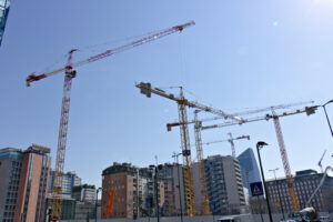 Costruzioni Milano. Area di un cantiere edile con gru a torre. Sullo sfondo la Diamond tower della BNL BNP Paribas. - MyVideoimage.com | Foto stock & Video footage