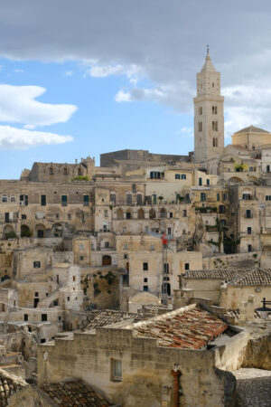 Costruzioni in tufo a Matera. View of the city of Matera in Italy. Church with bell tower and houses built in beige tuff stone. - MyVideoimage.com | Foto stock & Video footage