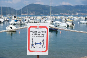 Covid 19 period, warning signs with the sea in the background. - MyVideoimage.com | Foto stock & Video footage