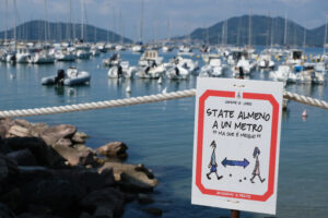 Covid 19 period, warning signs with the sea in the background. - MyVideoimage.com | Foto stock & Video footage