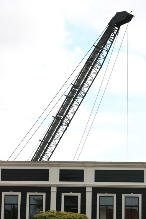 Cranes for loading. Cranes for loading and unloading of goods. In the foreground, a brown building with white windows. - MyVideoimage.com | Foto stock & Video footage