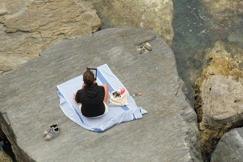 Distanziamento sociale. Social distancing. Young woman at the sea on the cliff. - MyVideoimage.com | Foto stock & Video footage