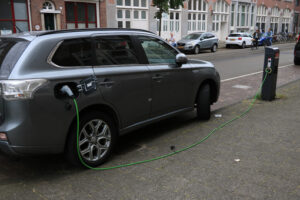 Electric car with charging cable and pedestal. Foto automobili. Cars photos.