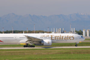 Emirates Boeing 777-300ER  airplane on the Malpensa airport runway.  In the background the mountains of the Alps. - MyVideoimage.com