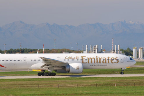 Emirates Boeing 777-300ER  airplane on the Malpensa airport runway.  In the background the mountains of the Alps. - MyVideoimage.com