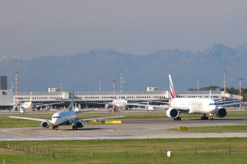 Emirates Boeing 777-31H  airplane on the Malpensa airport runway. 	In the background the terminal 1. - MyVideoimage.com