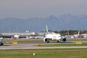 Emirates Boeing 777-31H  airplane on the Malpensa airport runway. 	In the background the terminal 1. - MyVideoimage.com