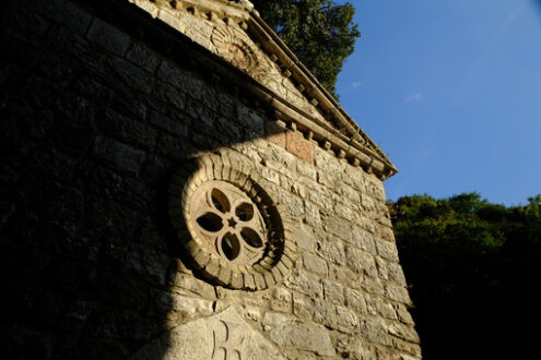 Eremo delle Carceri. Assisi. Hermitage of the Carceri of Assisi where St. Francis retired to pray. Small church with a rose window  within the architectural complex. - MyVideoimage.com | Foto stock & Video footage