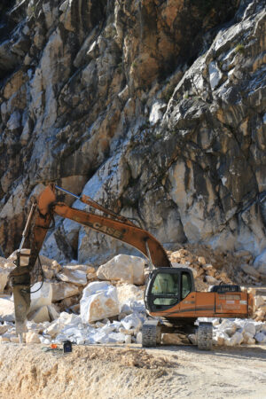 Escavatore con martello in cava di marmo. Excavator with demolition hammer in a Carrara marble quarry. - MyVideoimage.com | Foto stock & Video footage