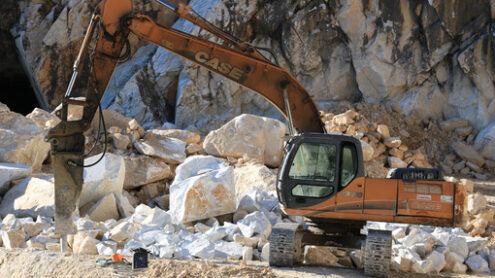 Escavatore in cava di marmo a Carrara. Excavator with demolition hammer in a Carrara marble quarry. Cave marmo. - MyVideoimage.com | Foto stock & Video footage