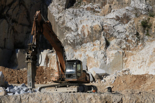 Excavator in a marble quarry. Excavator with demolition hammer in a Carrara marble quarry. - MyVideoimage.com | Foto stock & Video footage