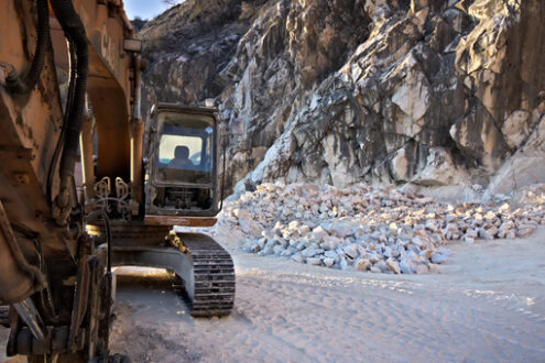 Excavator in a quarry. Apuan Alps, Carrara, Tuscany, Italy. March 28, 2019.  An excavator in a quarry of white Carrara marble. - MyVideoimage.com | Foto stock & Video footage