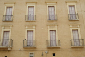 Facade of a Mediterranean palace with windows and balconies. Beige color plaster. - MyVideoimage.com