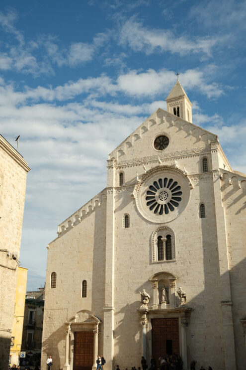 Facade of the Cathedral of San Sabino in Bari in limestone. Church with light stone walls with the blue sky background with clouds. Foto Bari photo.