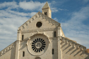 Facade of the Cathedral of San Sabino in Bari in limestone. Church with light stone walls with the blue sky background with clouds. Foto Bari photo.