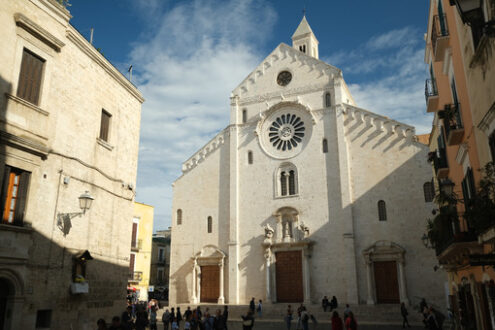 Facade of the Cathedral of San Sabino in Bari in limestone. Church with light stone walls with the blue sky background with clouds. Foto Bari photo.