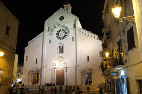 Facade of the Cathedral of San Sabino in Bari in limestone. Night shot with people walking. Foto Bari photo.