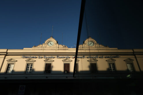 Facade of the La Spezia railway station with clock. Reflection of the mirror glass facade. - MyVideoimage.com