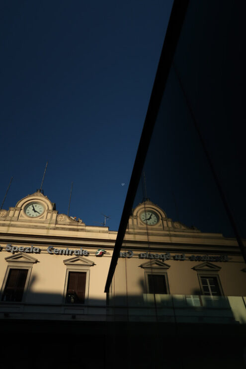 Facade of the La Spezia railway station with clock. Reflection of the mirror glass facade. - MyVideoimage.com