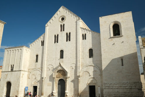 Façade of the church of San Nicola in Bari in limestone. Church with light stone walls with the blue sky background with clouds. Foto Bari photo.