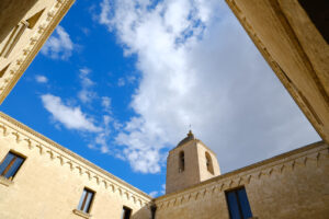 Facciata in tufo convento a matera. Convent of Sant’Agostino in Matera. Beige stone facade with blue sky and clouds. - MyVideoimage.com | Foto stock & Video footage