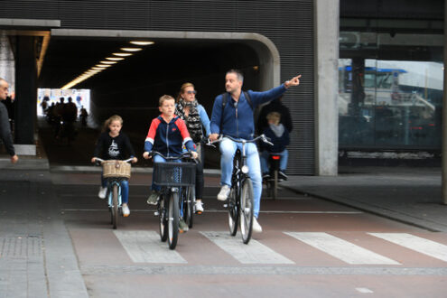 Family cycling to Amsterdam central station. Child, mom and dad - MyVideoimage.com