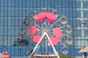 Ferris wheel with arrows symbols at the three Citylife towers in Milan. Between the mall and the skyscrapers a small ferris wheel. - MyVideoimage.com | Foto stock & Video footage