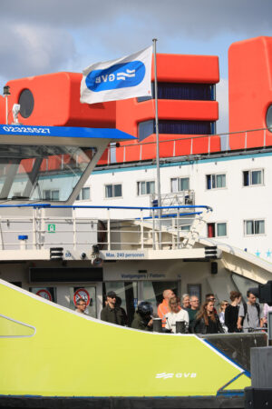 Ferry with people docked at the NDSM pier. In the background shi - MyVideoimage.com