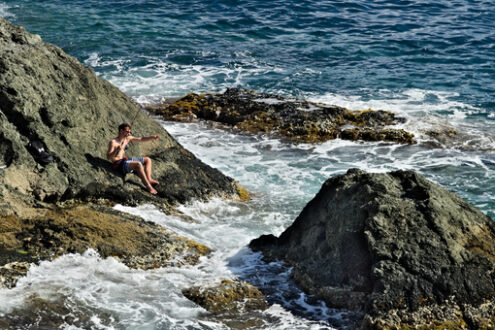 Fisherman Cinque Terre. Fisherman with fishing rod on a rock on the sea near the Cinque - MyVideoimage.com | Foto stock & Video footage