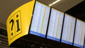 Flight info board at Amsterdam Schiphol airport. Help desk with - MyVideoimage.com