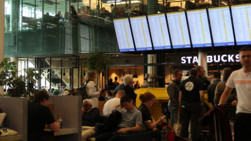 Flight info board at Amsterdam Schiphol airport. Help desk with - MyVideoimage.com