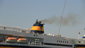 Fumaiolo di una nave. Smokestack of a large ship in the harbor. Black smoke comes from - MyVideoimage.com | Foto stock & Video footage