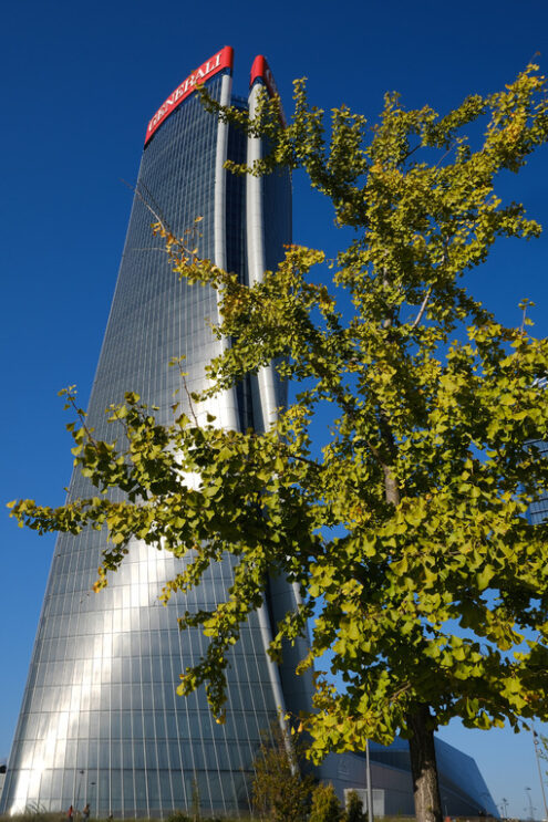 Generali skyscraper in Milan. Generali Assicurazioni skyscraper in Milan Citylife surrounded by trees with green leaves. - MyVideoimage.com | Foto stock & Video footage