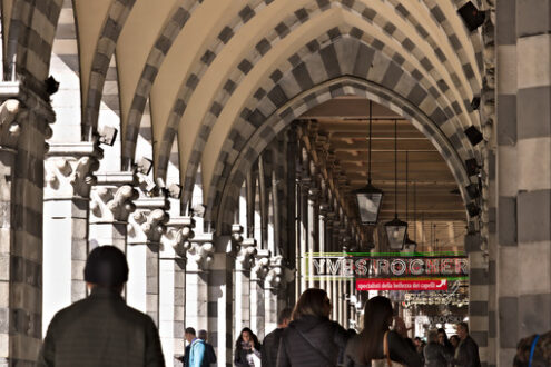 Genoa. People walk under an ancient arcade - MyVideoimage.com | Foto stock & Video footage