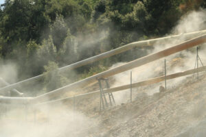 Geothermal power station. Geothermal field with fumaroles and steam pipes. Geothermal power station.Condensation towers in reinforced concrete. Larderello, Tuscany - MyVideoimage.com | Foto stock & Video footage