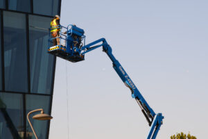 Glass facade cleaning. Worker on an elevator basket cleans the facade of a glass-clad building. - MyVideoimage.com | Foto stock & Video footage