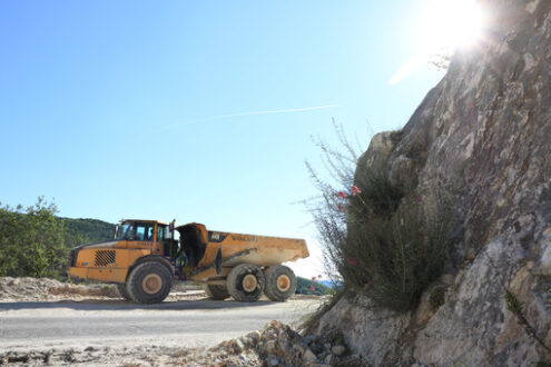 Grande camion in cava di marmo. A dumper truck used in a Carrara marble quarry. Large yellow dumper. - MyVideoimage.com | Foto stock & Video footage