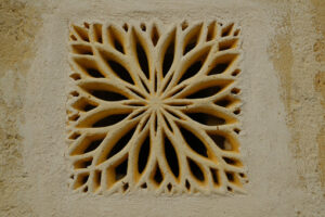 Griglia di ventilazione. Ventilation grid on the front of a house. Made of stone with a decorative shape. Matera, Italy. - MyVideoimage.com | Foto stock & Video footage