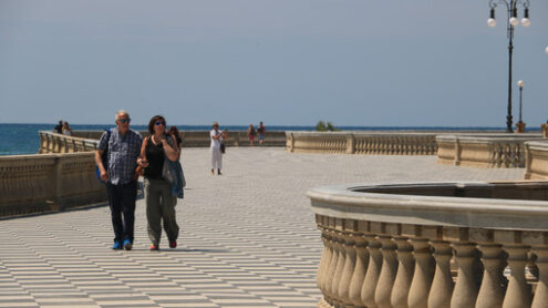 Group of people walking on the seafront of Livorno. The  Mascagni terrace is a famous place and meeting place for the citizens of the Tuscan city. - MyVideoimage.com