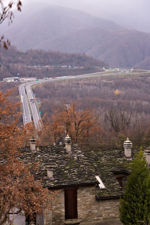 Highway of the Cisa. Asphalt strip running through the mountains of Tuscany and Emilia. Stone house and trees with yellow leaves. - MyVideoimage.com