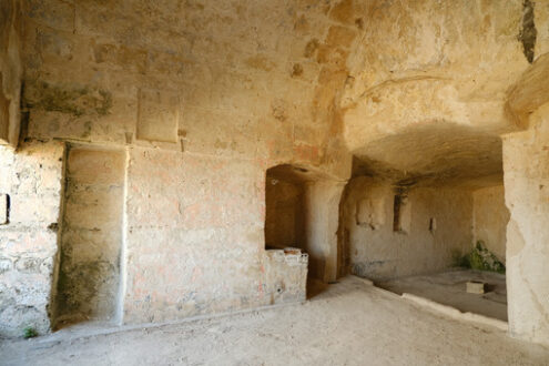 House carved into the rock. Sassi of Matera with arched ceilings and vaults. Ancient underground house dug out of the tufa rock. - MyVideoimage.com | Foto stock & Video footage