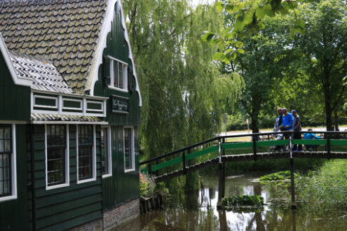 House on the stream. Wooden house on the stream. River bridge with people and childre - MyVideoimage.com | Foto stock & Video footage