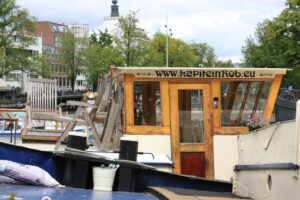 Houseboats and boats in an Amsterdam canal. Boats converted into dwellings anchored on the city canals. - MyVideoimage.com